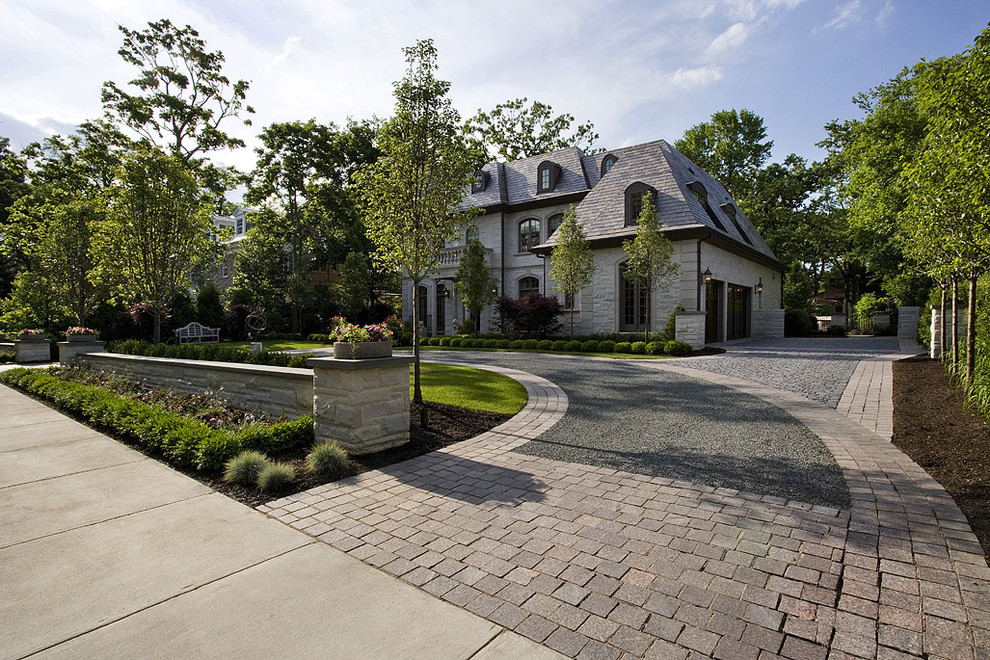 Design ideas for a large traditional full sun front yard stone driveway in Chicago for summer.