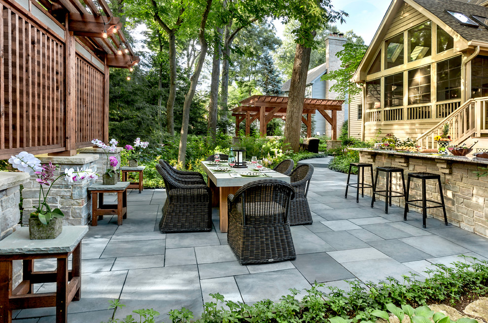 Foto di un patio o portico tradizionale dietro casa con pavimentazioni in pietra naturale