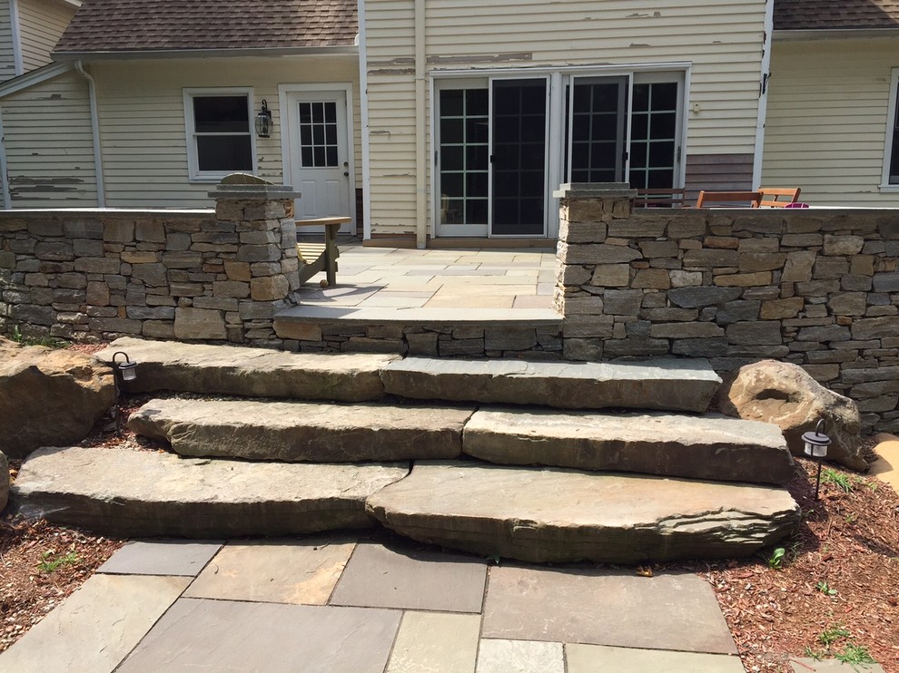 This is an example of a traditional back garden in Bridgeport with an outdoor sport court and a retaining wall.