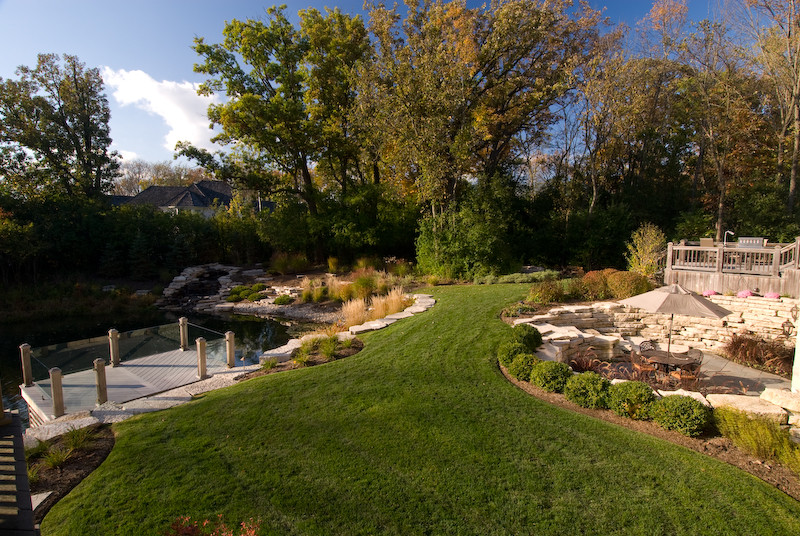 Diseño de jardín tradicional renovado extra grande en patio trasero con jardín francés y adoquines de piedra natural