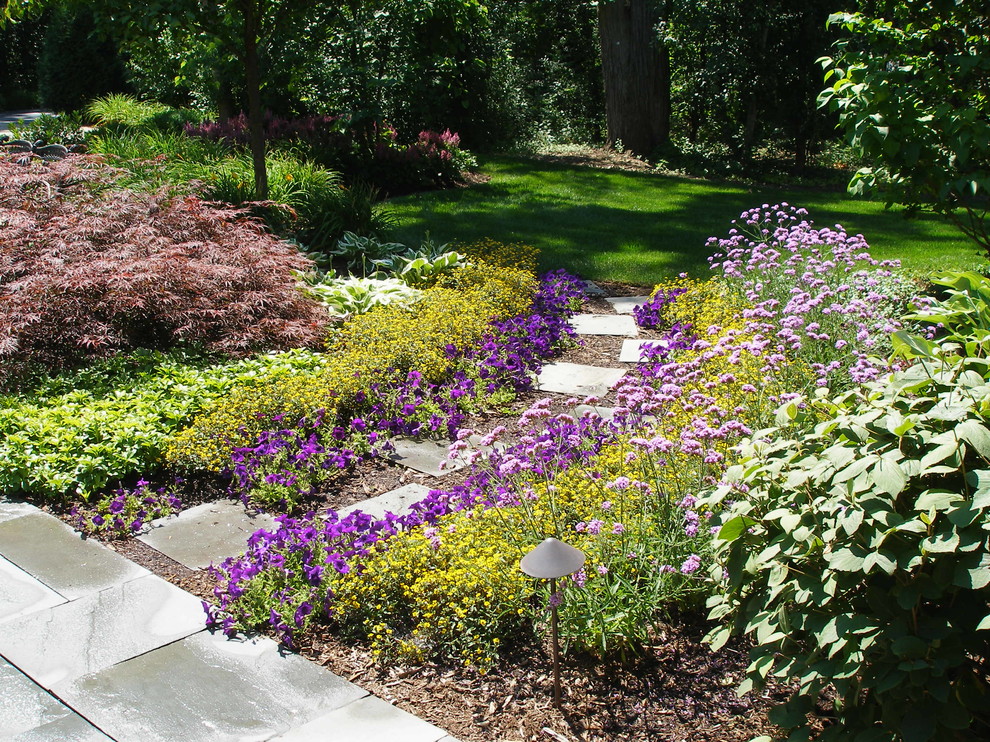 Exempel på en mycket stor klassisk trädgård, med naturstensplattor
