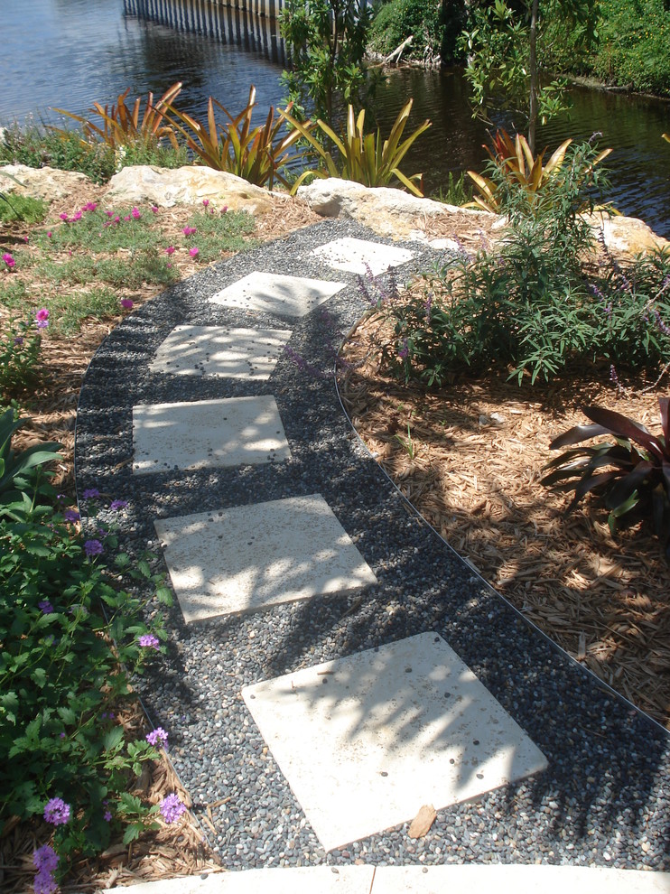 Idee per un giardino tropicale esposto in pieno sole di medie dimensioni e dietro casa in estate con pavimentazioni in pietra naturale