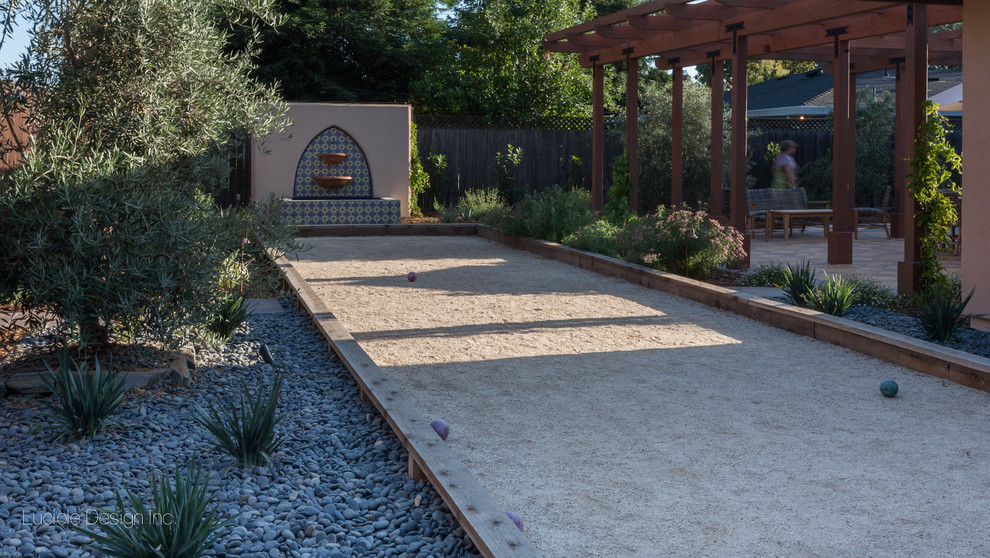 This is an example of a medium sized mediterranean back full sun garden in Sacramento with an outdoor sport court and decomposed granite.
