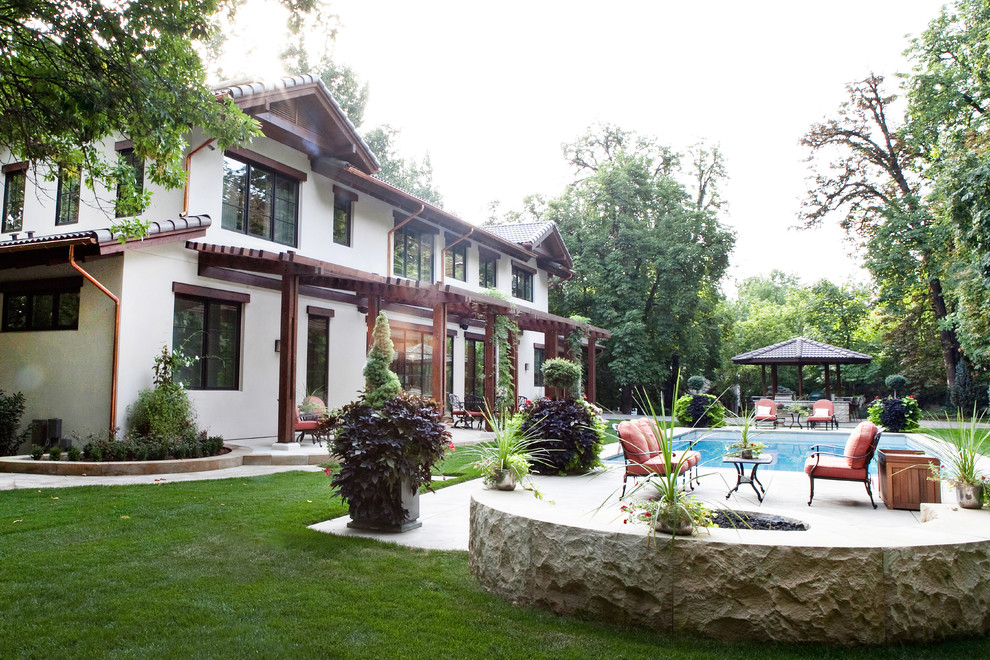 Diseño de jardín mediterráneo grande en verano en patio con exposición total al sol y adoquines de hormigón