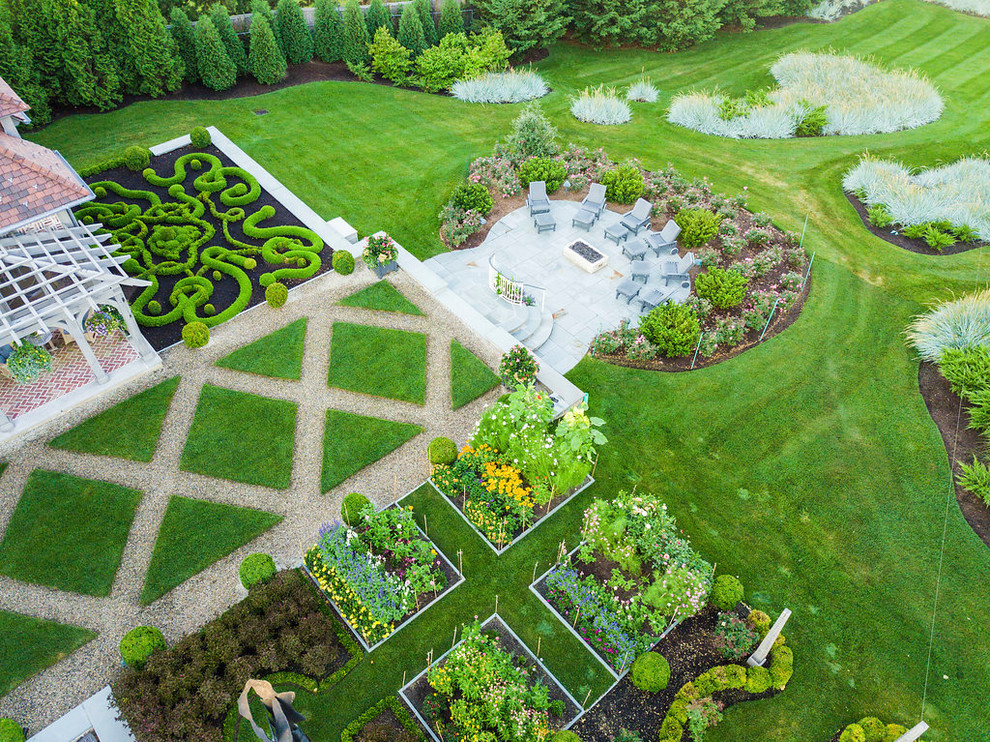 Inspiration för mycket stora klassiska formella trädgårdar i full sol framför huset på våren, med en vertikal trädgård och grus