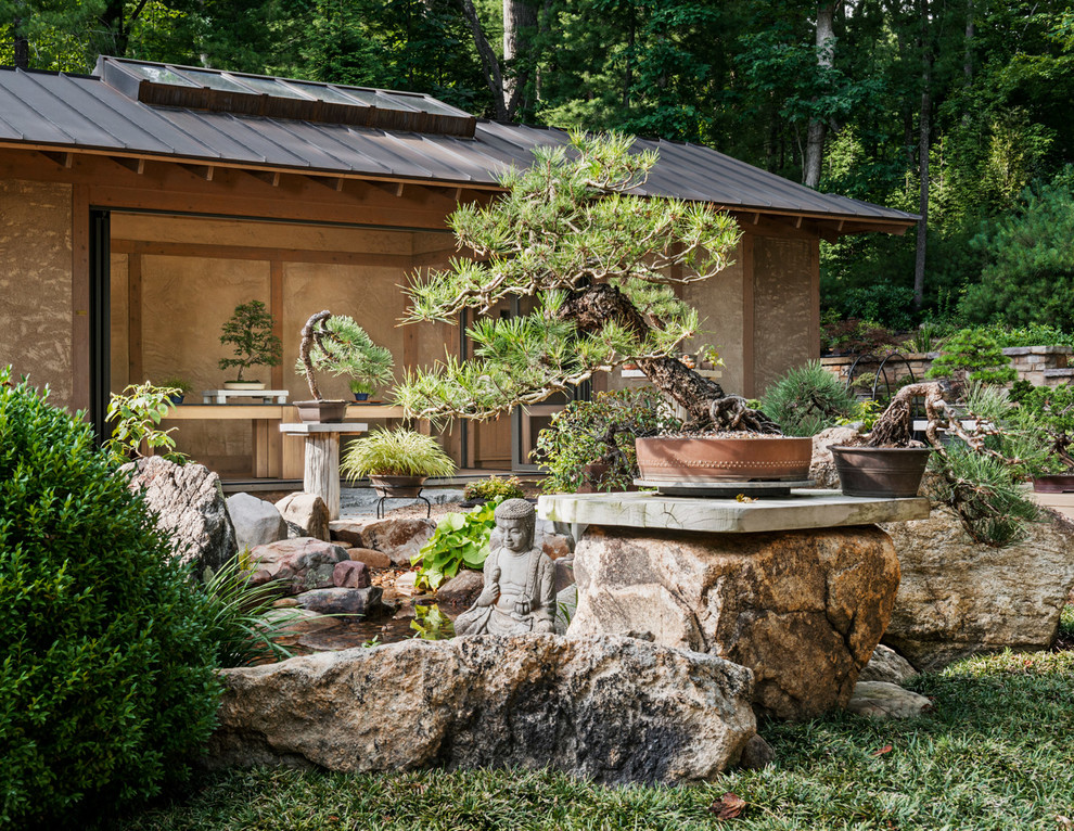 Réalisation d'un petit jardin à la française arrière asiatique avec un point d'eau, une exposition ensoleillée et des pavés en pierre naturelle.