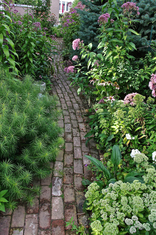 Immagine di un piccolo giardino design esposto a mezz'ombra nel cortile laterale in estate con pavimentazioni in mattoni