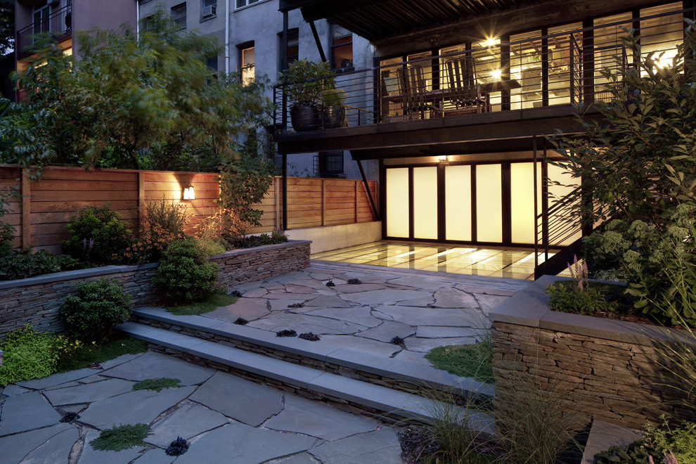 Immagine di un giardino minimal di medie dimensioni e dietro casa con pavimentazioni in pietra naturale