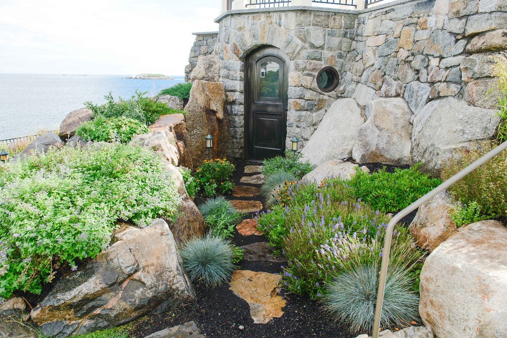 Foto di un giardino stile marino di medie dimensioni e dietro casa con un muro di contenimento e pavimentazioni in pietra naturale
