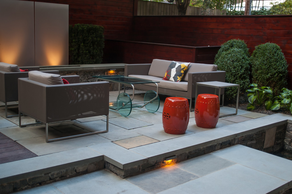 Photo of a small contemporary courtyard patio in Boston with natural stone paving and a fire feature.