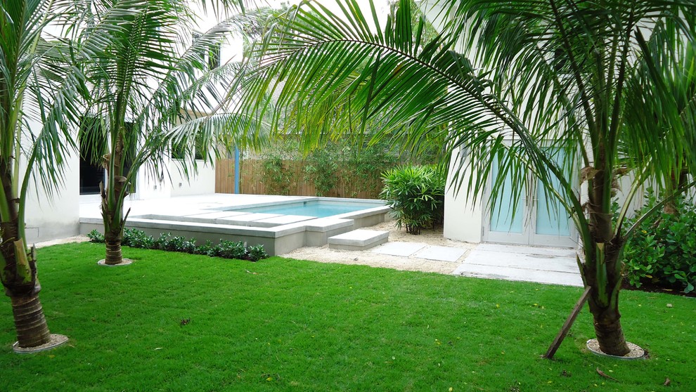 Modelo de jardín exótico de tamaño medio en patio trasero con fuente y exposición parcial al sol