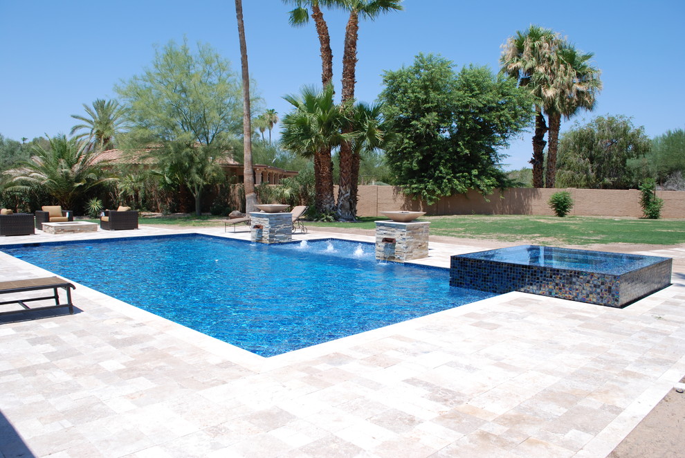 На фото: большой бассейн на заднем дворе в современном стиле с покрытием из каменной брусчатки с