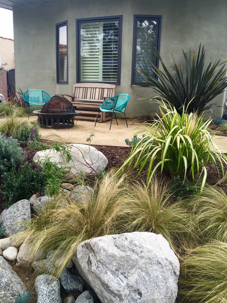 Immagine di un giardino minimal esposto in pieno sole di medie dimensioni e davanti casa con un focolare e pavimentazioni in pietra naturale