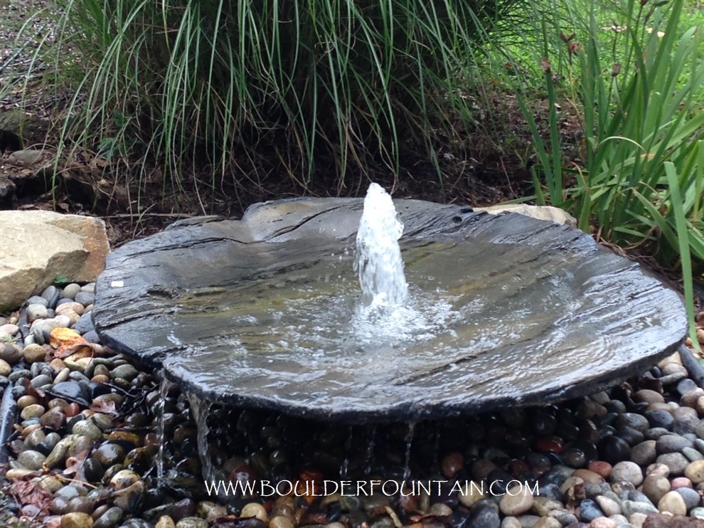 Rustic garden in Other with a water feature.
