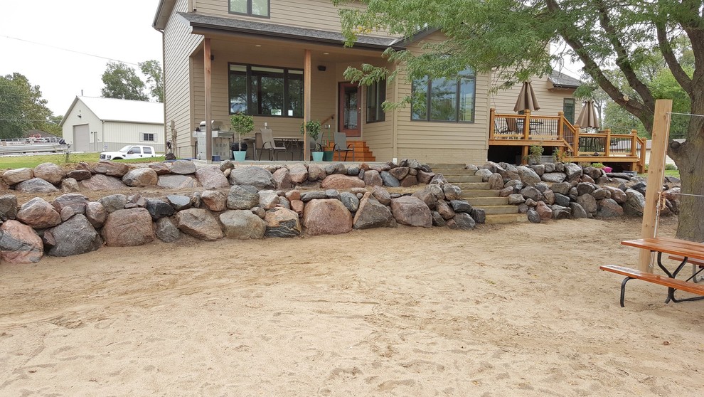 This is an example of a large coastal backyard retaining wall landscape in Omaha.