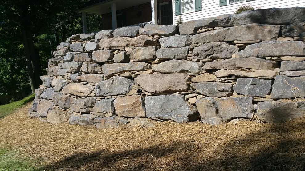 This is an example of a mid-sized traditional front yard retaining wall landscape in Other.