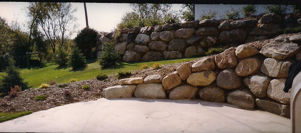Design ideas for a mid-sized traditional backyard concrete paver retaining wall landscape in Minneapolis.
