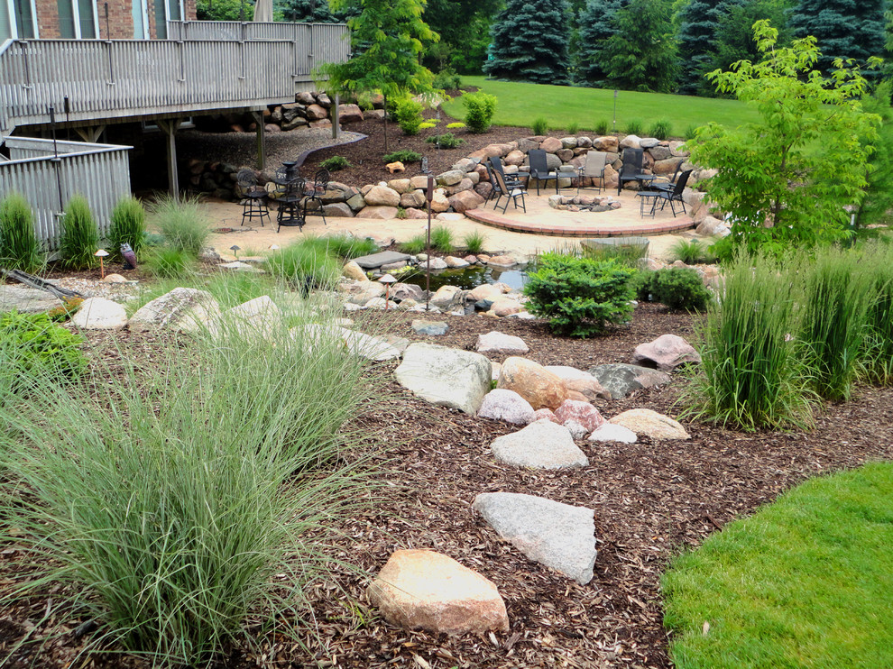 Design ideas for a large traditional full sun backyard mulch landscaping in Cedar Rapids with a fire pit.
