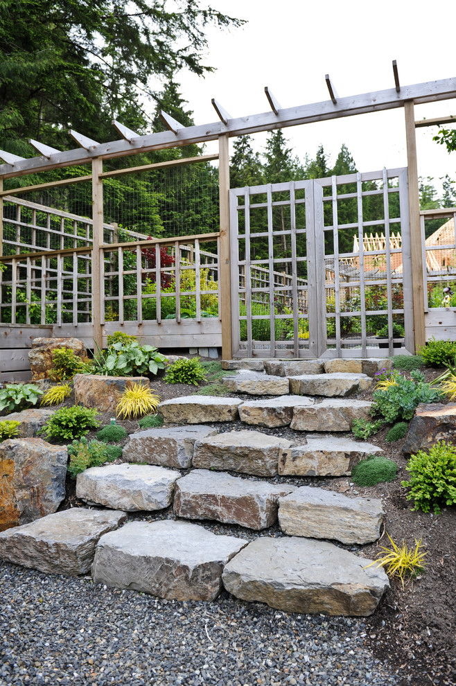 Modelo de jardín tradicional renovado en ladera con adoquines de piedra natural y pérgola