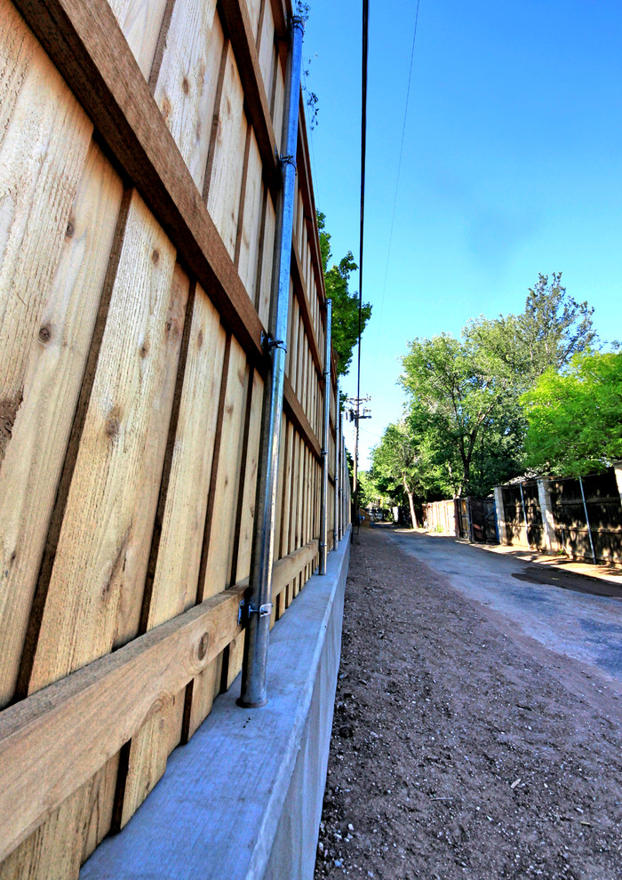 Große Rustikale Gartenmauer hinter dem Haus mit Betonboden in Austin