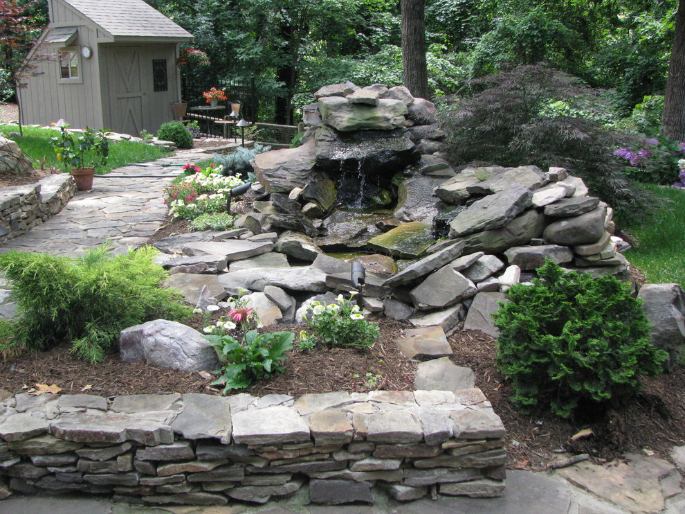 Design ideas for a mid-sized traditional full sun backyard stone landscaping in Richmond.