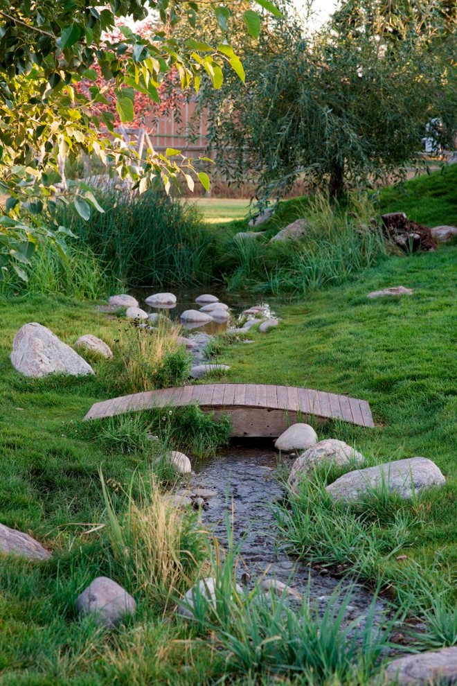 Cette image montre un jardin chalet de taille moyenne avec un point d'eau et une pente, une colline ou un talus.