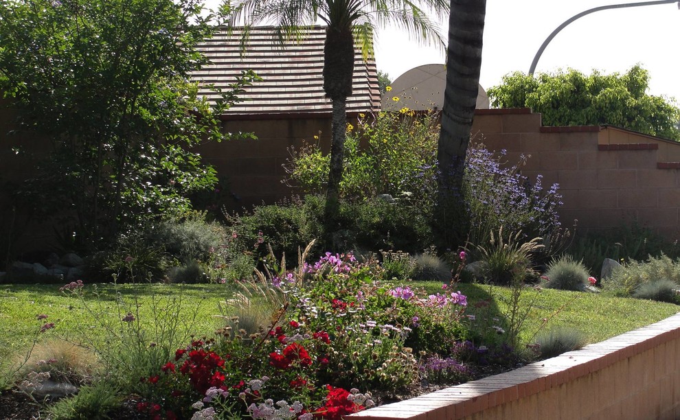 Foto di un giardino formale tradizionale esposto a mezz'ombra di medie dimensioni e davanti casa in primavera con un ingresso o sentiero e pavimentazioni in pietra naturale