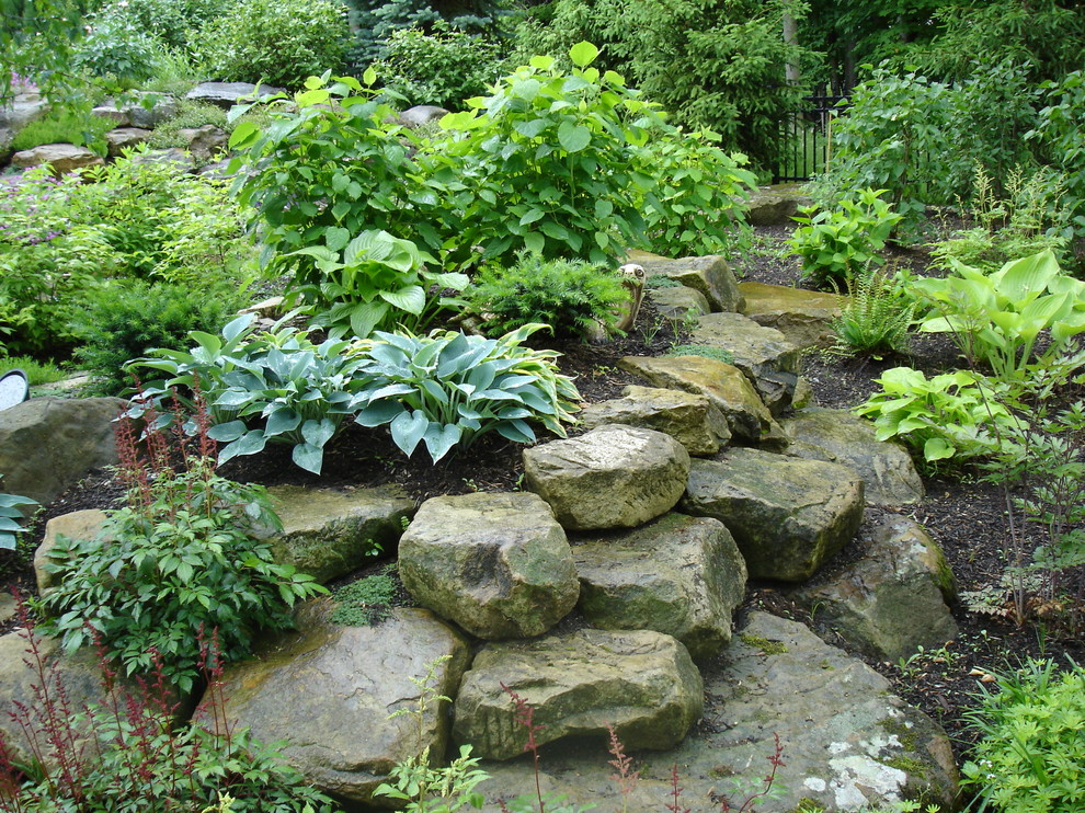 Inspiration for a large transitional shade backyard stone retaining wall landscape in Cleveland for spring.