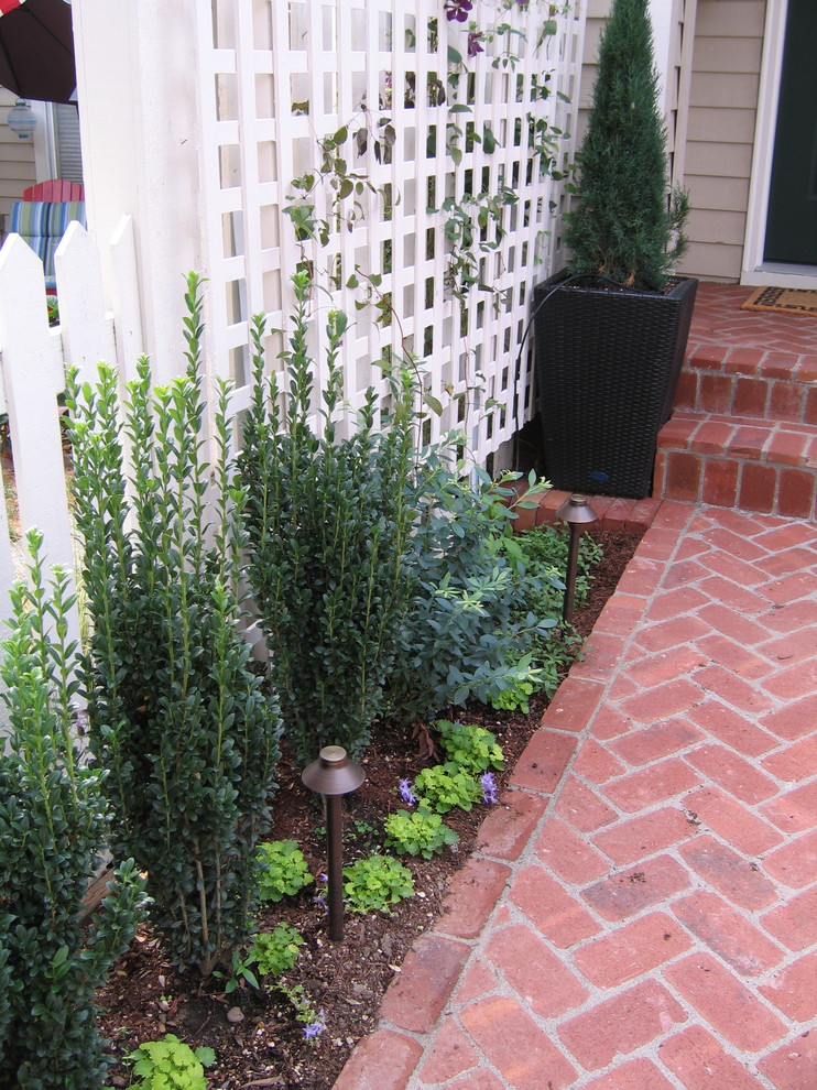 Photo of a small traditional partial sun front yard brick landscaping in Portland.