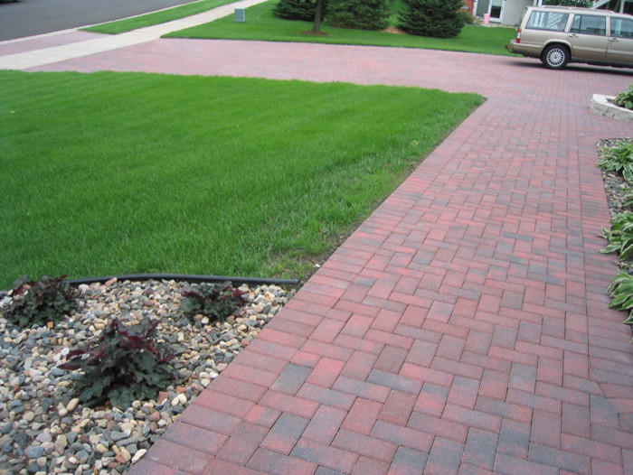 Large traditional front driveway full sun garden in Minneapolis with brick paving.