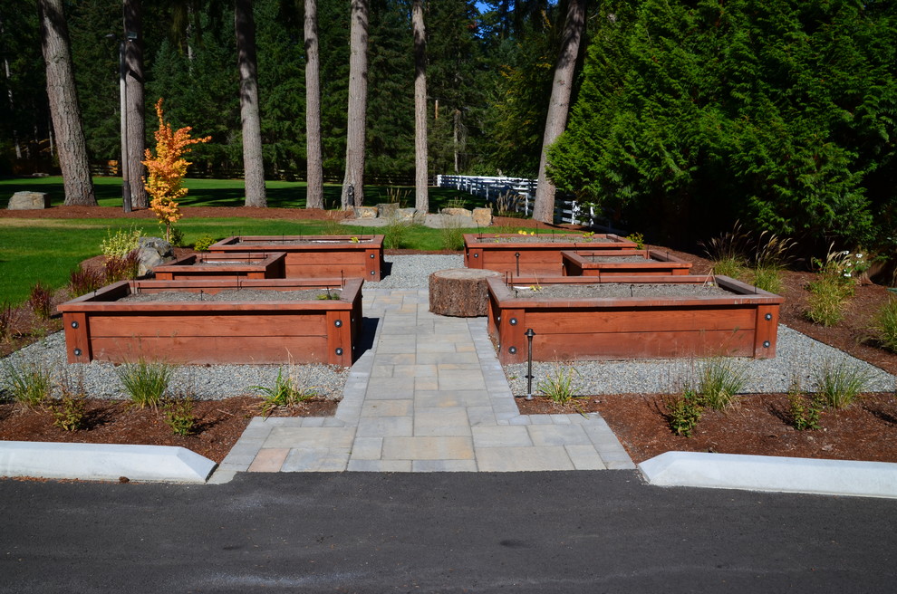 Large rustic back formal full sun garden for summer in Seattle with a garden path and concrete paving.