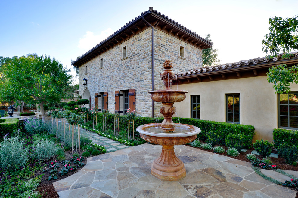 Design ideas for an expansive traditional side formal partial sun garden for spring in San Diego with a water feature and natural stone paving.