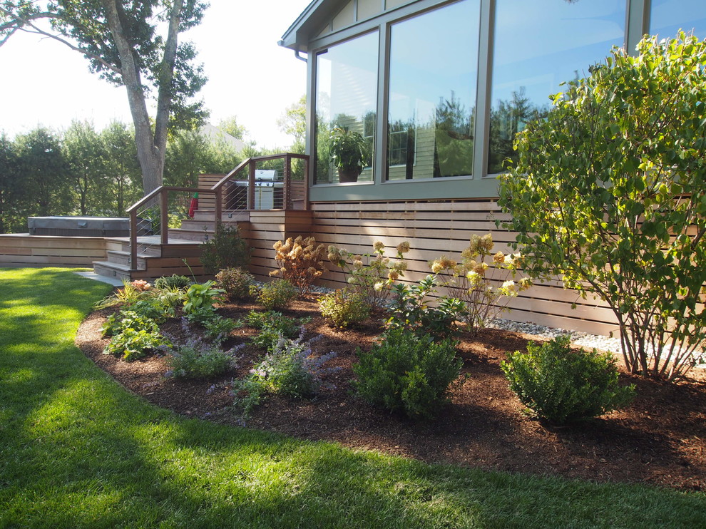 This is an example of a mid-sized modern full sun front yard landscaping in Providence with decking for spring.