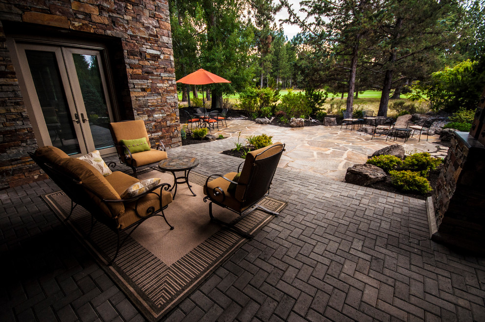 This is an example of a large rustic drought-tolerant and full sun backyard stone landscaping in Other with a fire pit for summer.