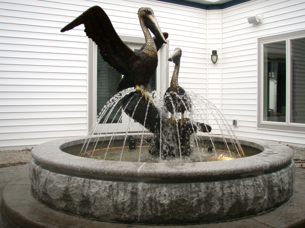 Inspiration for a mid-sized eclectic courtyard water fountain landscape in Milwaukee.