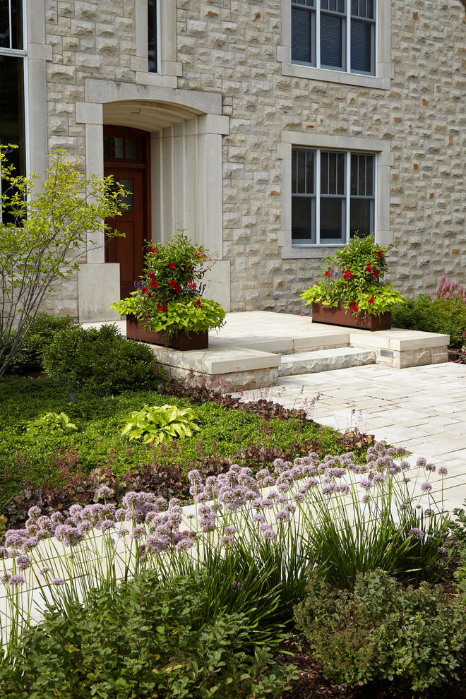 Foto de jardín actual de tamaño medio en patio delantero con adoquines de piedra natural y muro de contención