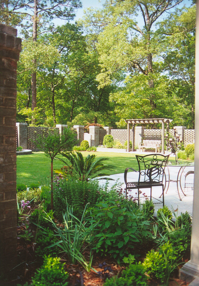 Inspiration för en mellanstor amerikansk trädgård i full sol på våren, med marksten i tegel och en stödmur