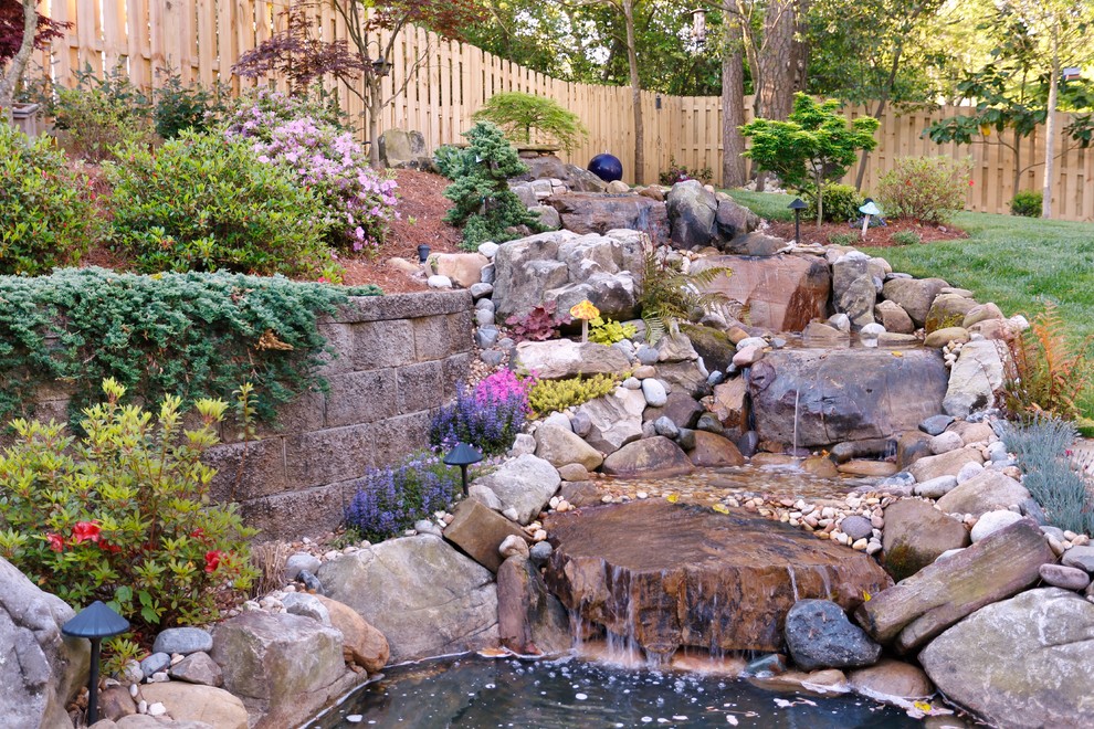 Cette image montre un grand jardin arrière sud-ouest américain au printemps avec une exposition partiellement ombragée et des pavés en pierre naturelle.