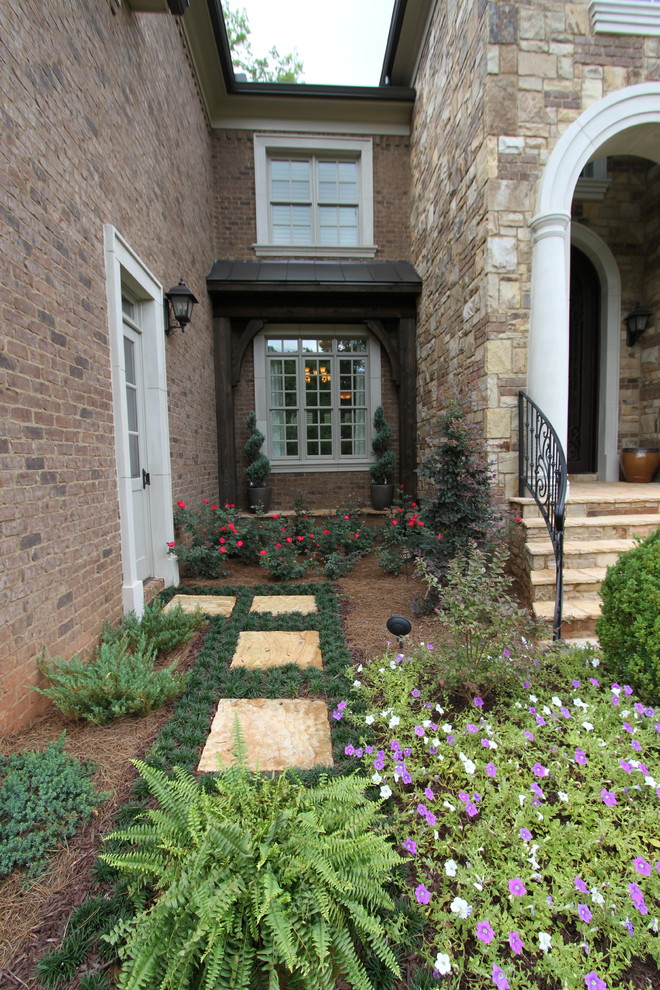 Imagen de camino de jardín clásico de tamaño medio en patio lateral con jardín francés, exposición parcial al sol y adoquines de piedra natural