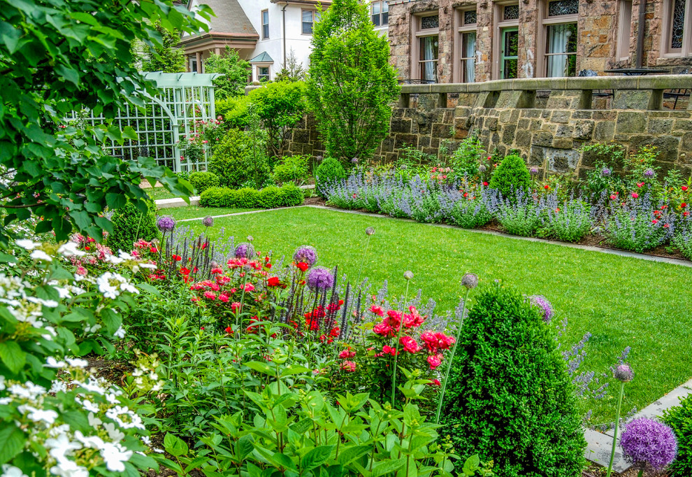 Cette image montre un jardin à la française latéral traditionnel de taille moyenne avec une exposition ensoleillée et des pavés en pierre naturelle.