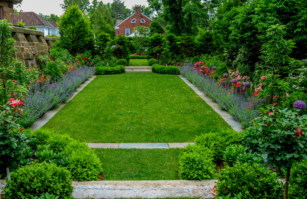 Ejemplo de jardín tradicional de tamaño medio en patio lateral con jardín francés, exposición total al sol y adoquines de piedra natural