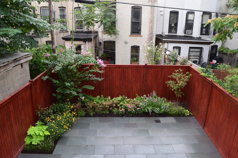 Immagine di un piccolo giardino formale minimal esposto in pieno sole dietro casa in estate con pavimentazioni in pietra naturale
