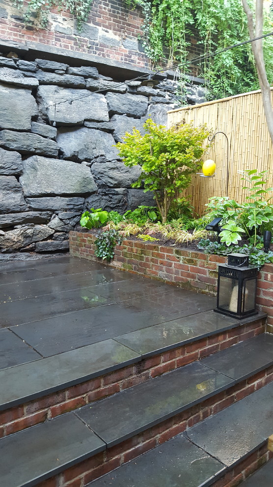 Photo of a small eclectic shade backyard stone formal garden in New York for winter.