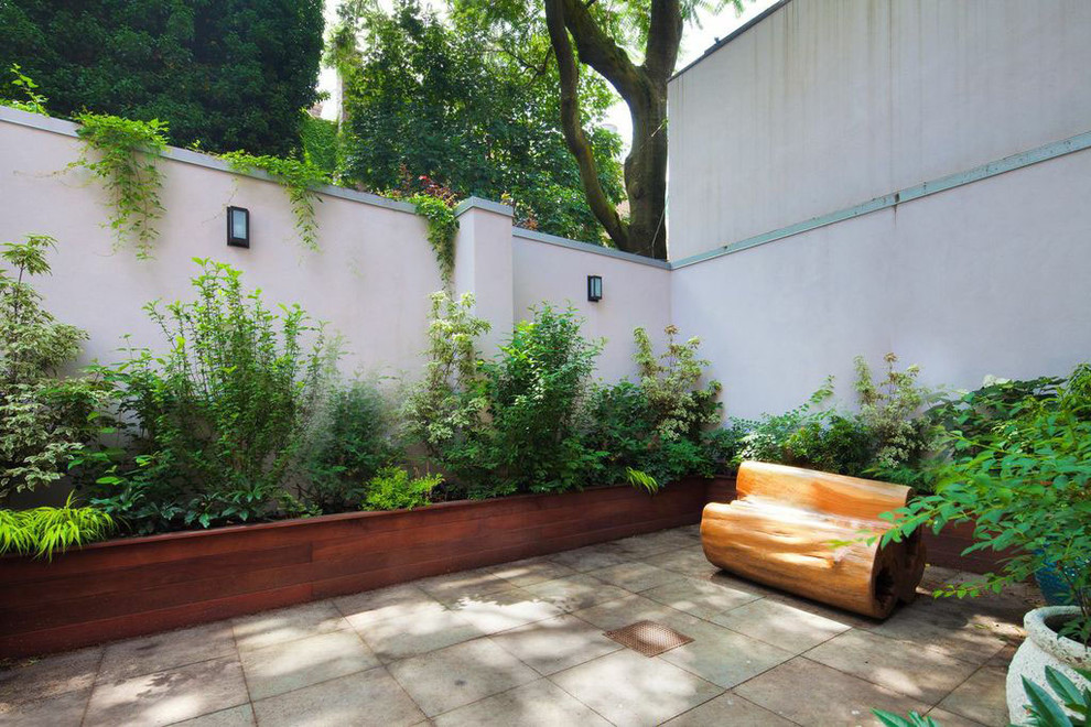 На фото: тенистый участок и сад на заднем дворе в современном стиле с растениями в контейнерах и покрытием из каменной брусчатки с