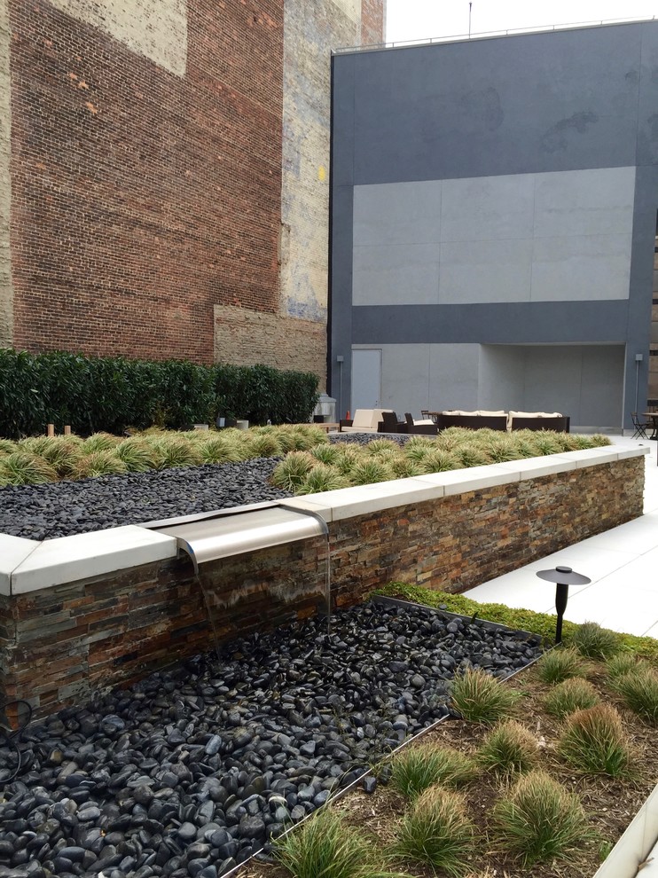 Esempio di un giardino formale minimal esposto in pieno sole di medie dimensioni e in cortile con fontane e pavimentazioni in cemento