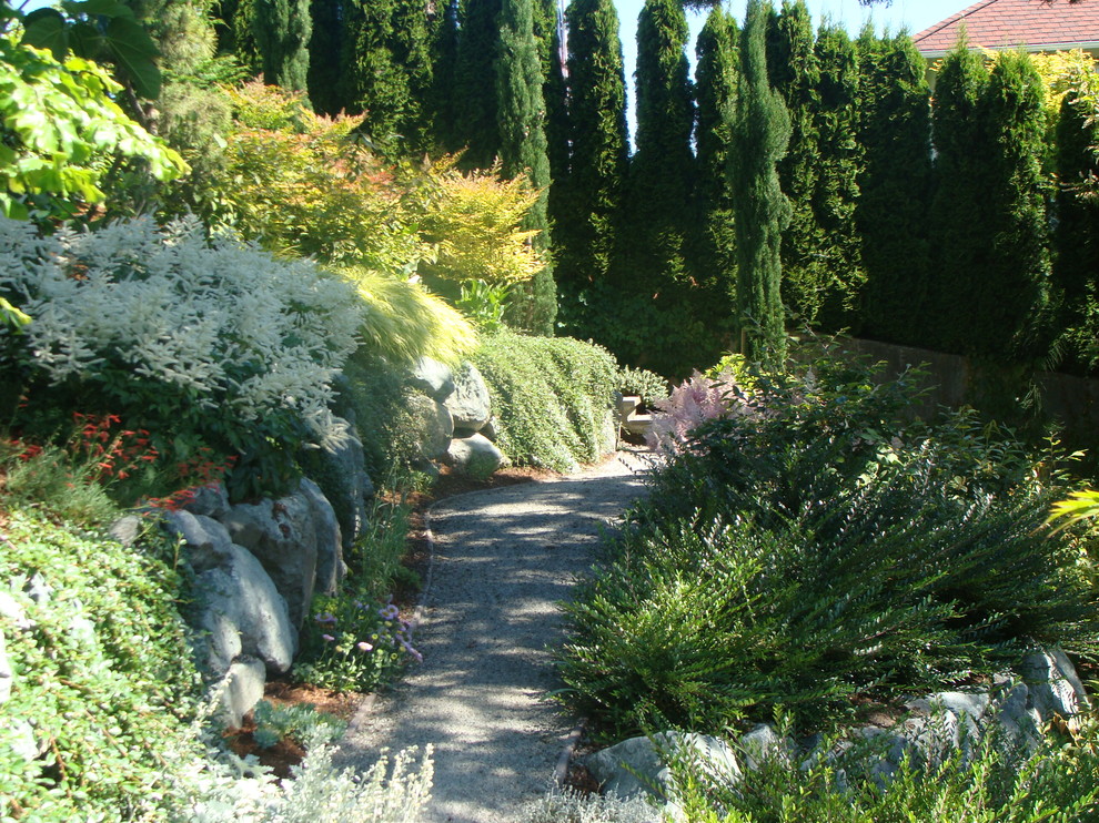 Réalisation d'un jardin tradition l'automne avec une pente, une colline ou un talus et du gravier.