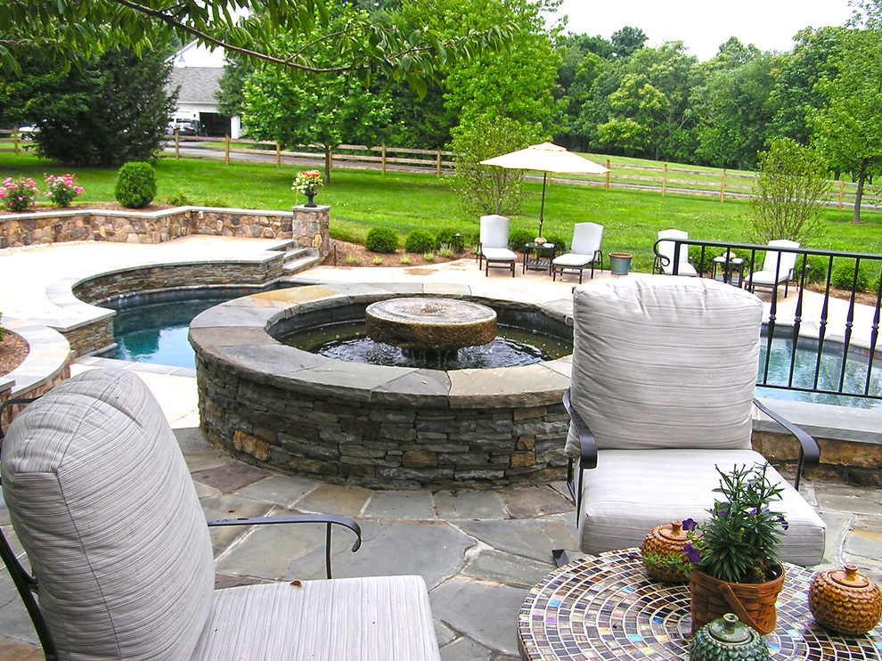 Photo of a large traditional full sun backyard stone water fountain landscape in DC Metro.