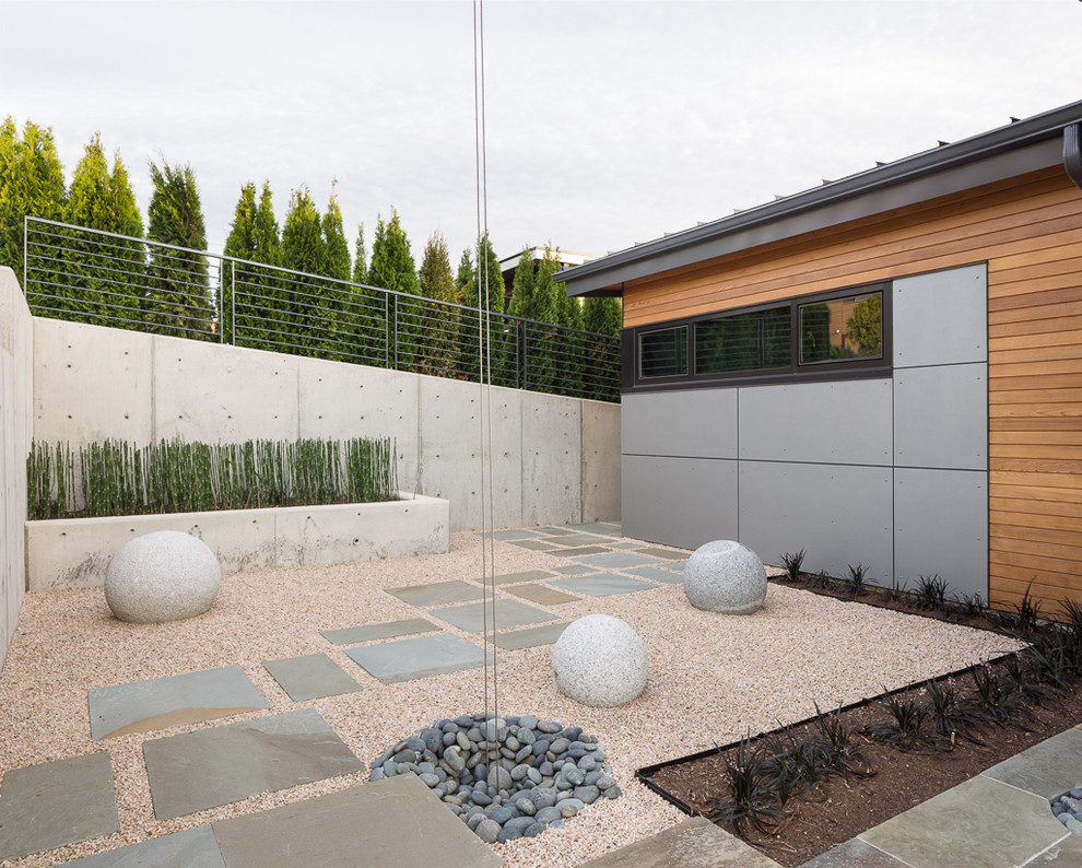 На фото: регулярный сад среднего размера на внутреннем дворе в стиле модернизм с полуденной тенью и покрытием из гравия с