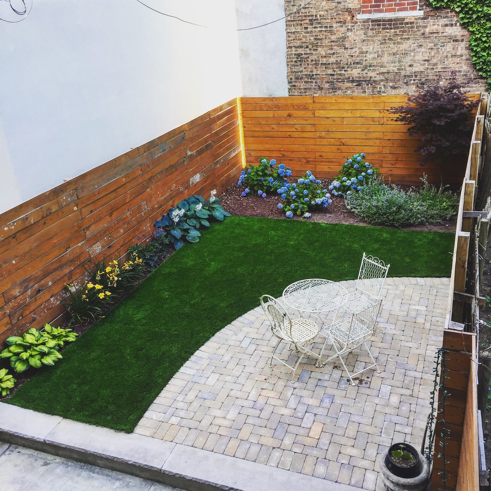 Modelo de jardín moderno de tamaño medio en patio trasero con exposición total al sol y adoquines de hormigón