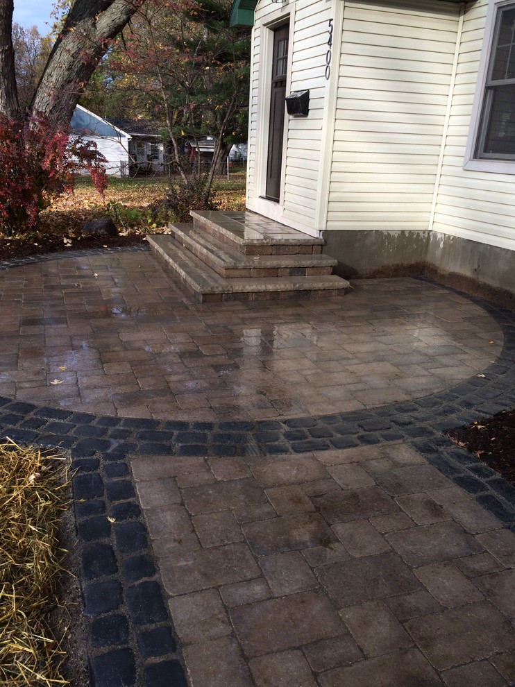 This is an example of a small traditional partial sun front yard concrete paver landscaping in Other for summer.